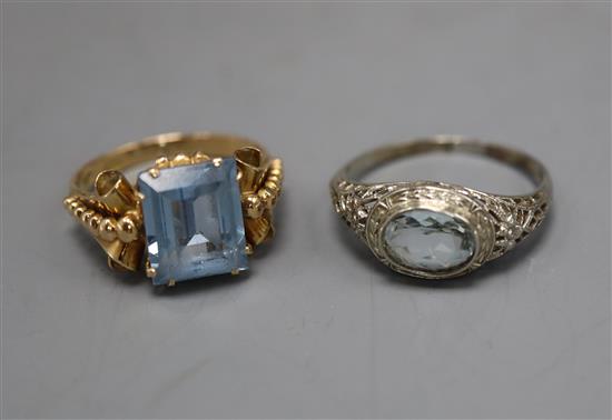 A 14k white metal and aquamarine ring and a 750 yellow metal and synthetic spinel? ring.